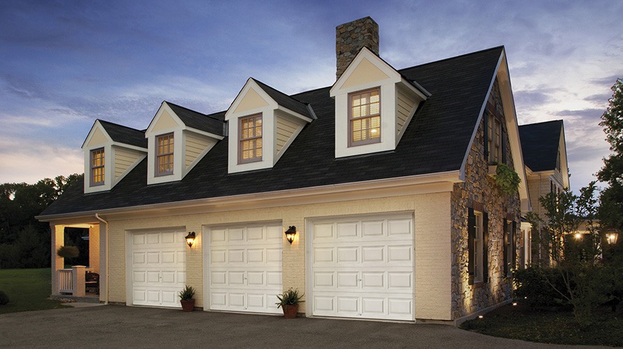 clopay classic collection white garage doors on house at night