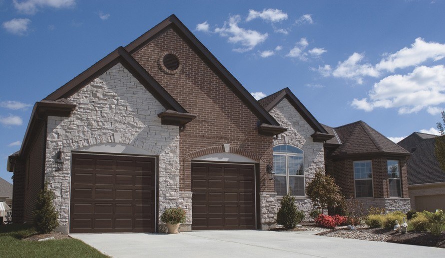 clopay classic wood collection garage doors on brick house